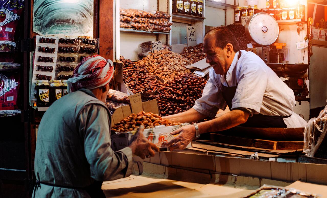 A photo of an interaction between a buyer and a seller in a bazaar.